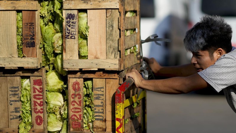 Perempuan mengumpulkan sayuran untuk dibawa pulang setelah dibuang oleh penjual di pasar di pinggiran Buenos Aires, Argentina, Rabu, 10 Januari 2024. (AP Photo/Natacha Pisarenko)
