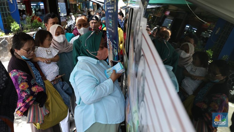 Warga melakukan penukaran uang pecahan di mobil kas keliling Bank Indonesia yang melayani penukaran uang pecahan di Pasar Slipi, Jakarta, Rabu (20/3/2024). (CNBC Indonesia/Tri Susilo)