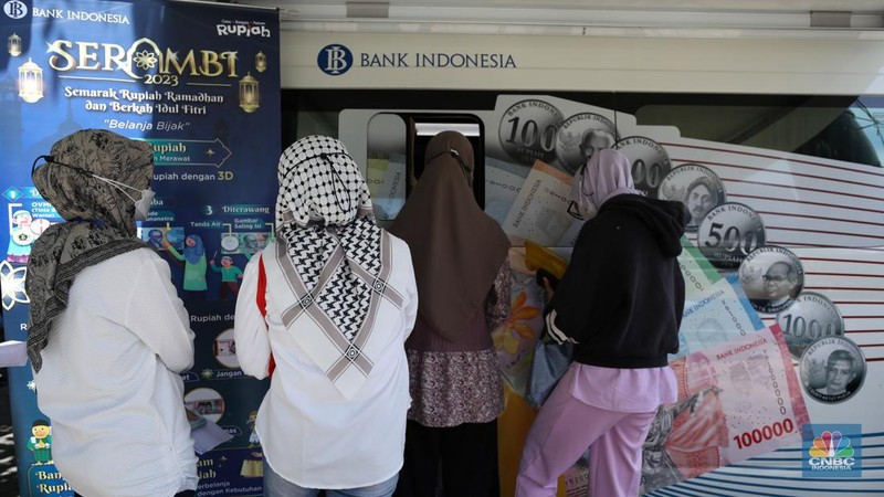 Warga melakukan penukaran uang pecahan di mobil kas keliling Bank Indonesia yang melayani penukaran uang pecahan di Pasar Slipi, Jakarta, Rabu (20/3/2024). (CNBC Indonesia/Tri Susilo)