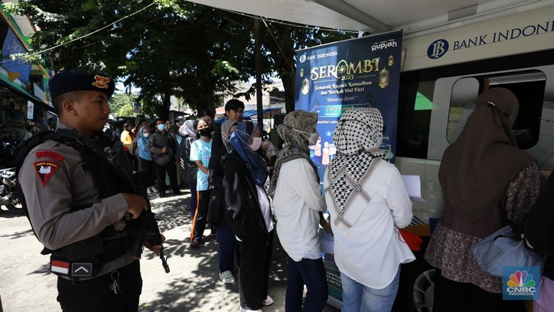 Warga melakukan penukaran uang pecahan di mobil kas keliling Bank Indonesia yang melayani penukaran uang pecahan di Pasar Slipi, Jakarta, Rabu (20/3/2024). (CNBC Indonesia/Tri Susilo)