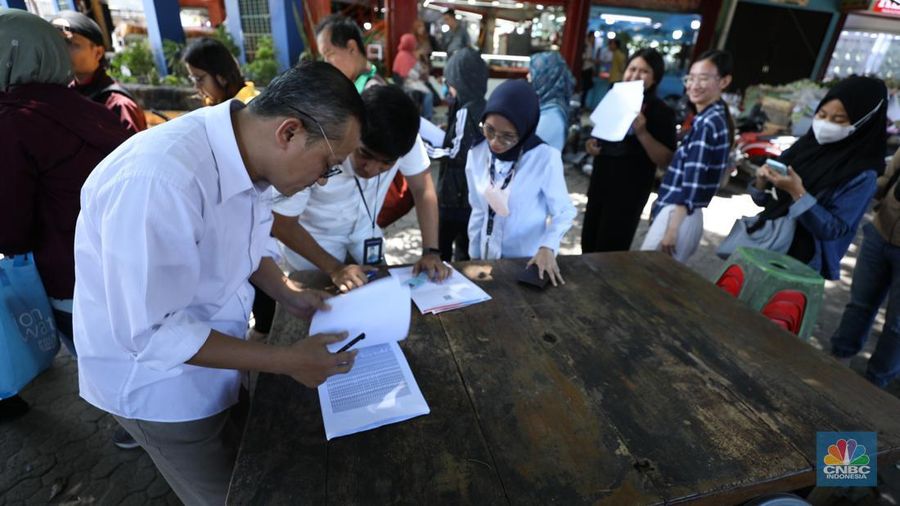 Warga melakukan penukaran uang pecahan di mobil kas keliling Bank Indonesia yang melayani penukaran uang pecahan di Pasar Slipi, Jakarta, Rabu (20/3/2024). (CNBC Indonesia/Tri Susilo)