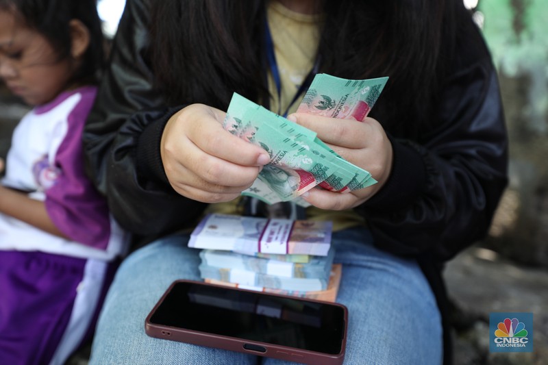 Warga melakukan penukaran uang pecahan di mobil kas keliling Bank Indonesia yang melayani penukaran uang pecahan di Pasar Slipi, Jakarta, Rabu (20/3/2024). (CNBC Indonesia/Tri Susilo)