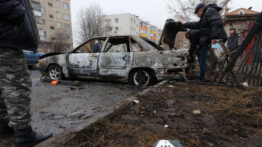 Warga memerika mobil yang rusak usai terkena serangan militer Ukraina di pemukiman Razumnoe, Belgorod, Rusia, Selasa (19/3/2024) waktu setempat. (REUTERS/Stringer)