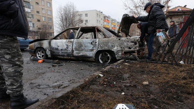 Warga memerika mobil yang rusak usai terkena serangan militer Ukraina di pemukiman Razumnoe, Belgorod, Rusia, Selasa (19/3/2024) waktu setempat. (REUTERS/Stringer)