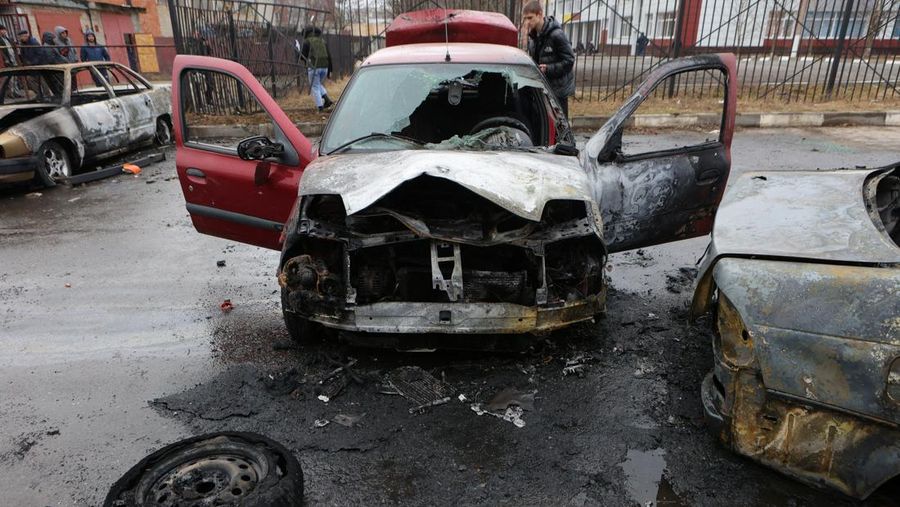 Warga memerika mobil yang rusak usai terkena serangan militer Ukraina di pemukiman Razumnoe, Belgorod, Rusia, Selasa (19/3/2024) waktu setempat. (REUTERS/Stringer)