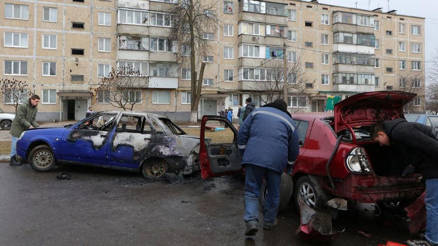 Warga memerika mobil yang rusak usai terkena serangan militer Ukraina di pemukiman Razumnoe, Belgorod, Rusia, Selasa (19/3/2024) waktu setempat. (REUTERS/Stringer)