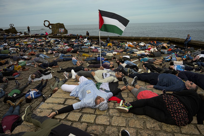 Spain Israel Palestinians Pro-Palestinian demonstrators lie on the ground as they protest against Israeli attacks on Gaza, in San Sebastian, northern Spain, on Sunday, March 17, 2024. (AP Photo/Alvaro Barrientos)