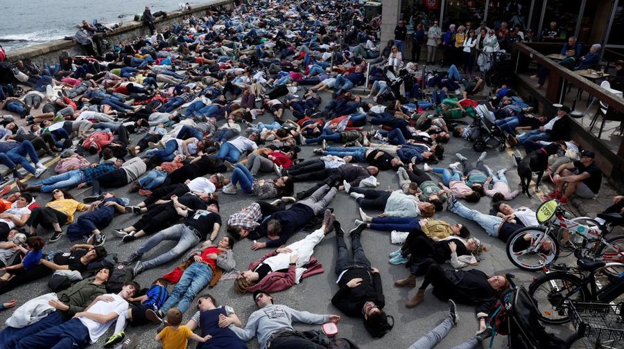 Pro-Palestinian demonstrators lie on the ground as they protest against Israeli attacks on Gaza, in San Sebastian, northern Spain, on Sunday, March 17, 2024. (AP Photo/Alvaro Barrientos)
