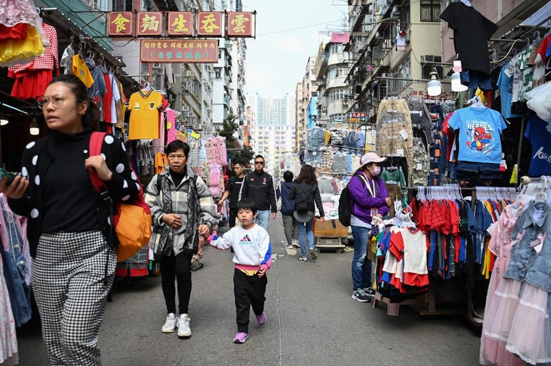 Orang-orang melintasi persimpangan di kawasan pusat bisnis Hong Kong pada 27 Februari 2024, sehari sebelum anggaran tahunan kota tersebut diumumkan pada 28 Februari. Orang-orang melintasi persimpangan di kawasan pusat bisnis Hong Kong pada 27 Februari 2024, sehari sebelum anggaran tahunan kota tersebut diumumkan pada 28 Februari. (Photo by Peter PARKS / AFP)