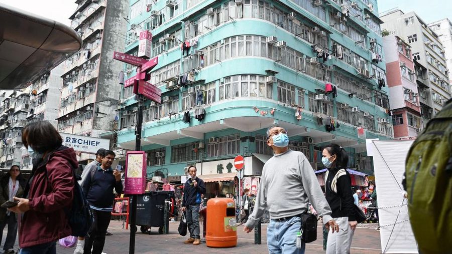 Orang-orang berjalan melalui lingkungan di distrik Kowloon, Hong Kong pada 27 Februari 2024, sehari sebelum anggaran tahunan kota tersebut diumumkan pada 28 Februari. (Photo by Peter PARKS / AFP)