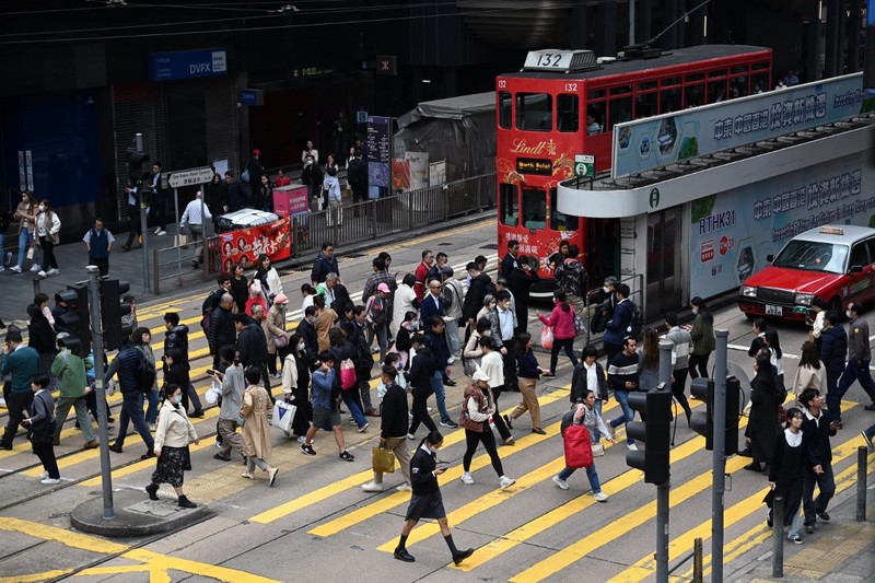 Orang-orang melintasi persimpangan di kawasan pusat bisnis Hong Kong pada 27 Februari 2024, sehari sebelum anggaran tahunan kota tersebut diumumkan pada 28 Februari. Orang-orang melintasi persimpangan di kawasan pusat bisnis Hong Kong pada 27 Februari 2024, sehari sebelum anggaran tahunan kota tersebut diumumkan pada 28 Februari. (Photo by Peter PARKS / AFP)