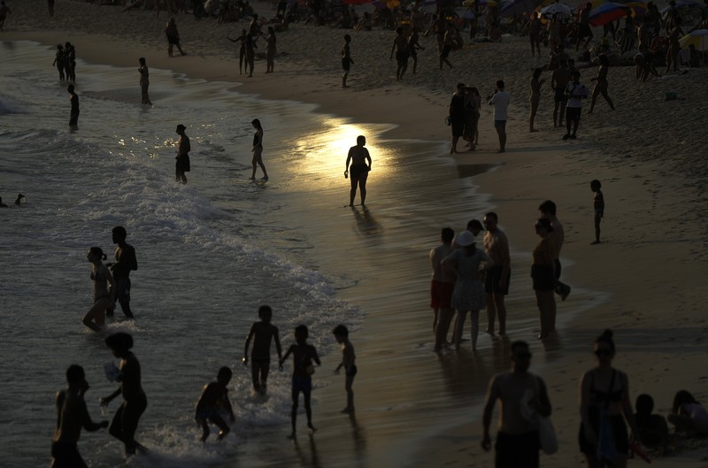 Orang-orang nongkrong di perairan dangkal pantai Arpoador di tengah gelombang panas, di Rio de Janeiro, Brasil, Rabu, 20 Maret 2024. Orang-orang nongkrong di perairan dangkal pantai Arpoador di tengah gelombang panas, di Rio de Janeiro, Brasil, Rabu, 20 Maret 2024. (AP Photo/Silvia Izquierdo)