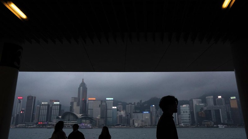 Orang-orang melintasi persimpangan di kawasan pusat bisnis Hong Kong pada 27 Februari 2024, sehari sebelum anggaran tahunan kota tersebut diumumkan pada 28 Februari. (Photo by Peter PARKS / AFP)