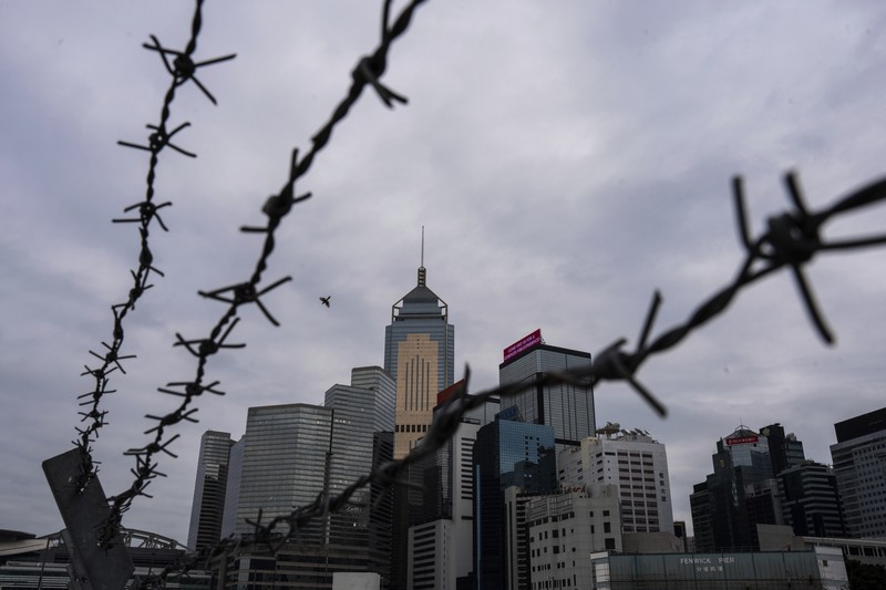 Orang-orang melintasi persimpangan di kawasan pusat bisnis Hong Kong pada 27 Februari 2024, sehari sebelum anggaran tahunan kota tersebut diumumkan pada 28 Februari. (Photo by Peter PARKS / AFP)