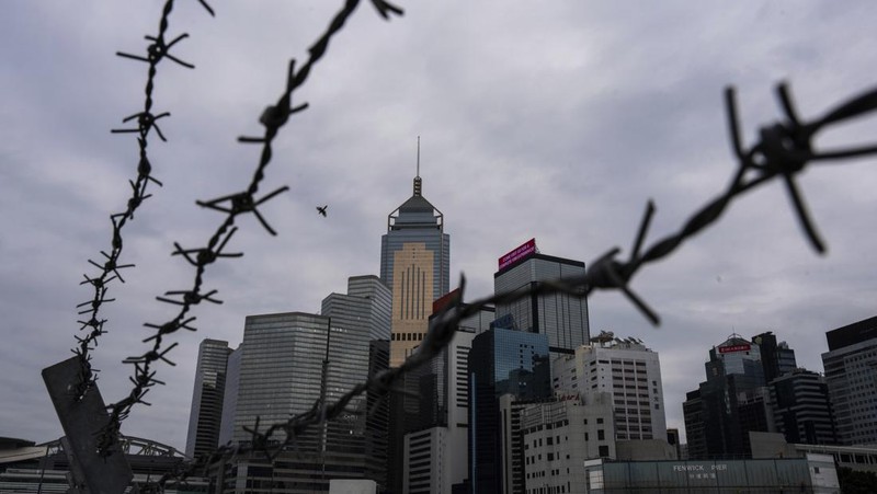 Orang-orang melintasi persimpangan di kawasan pusat bisnis Hong Kong pada 27 Februari 2024, sehari sebelum anggaran tahunan kota tersebut diumumkan pada 28 Februari. (Photo by Peter PARKS / AFP)