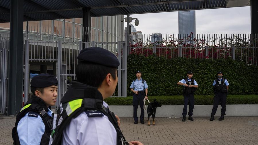 Orang-orang melintasi persimpangan di kawasan pusat bisnis Hong Kong pada 27 Februari 2024, sehari sebelum anggaran tahunan kota tersebut diumumkan pada 28 Februari. (Photo by Peter PARKS / AFP)