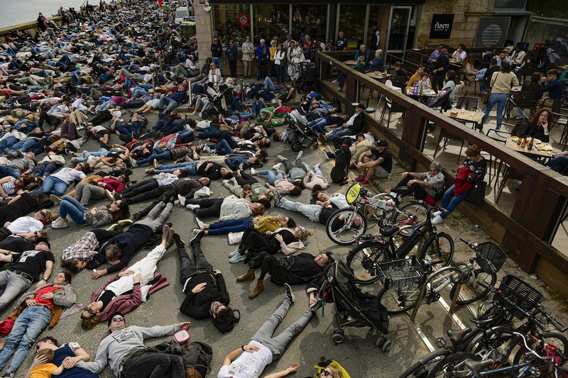 Pro-Palestinian demonstrators lie on the ground as they protest against Israeli attacks on Gaza, in San Sebastian, northern Spain, on Sunday, March 17, 2024. (AP Photo/Alvaro Barrientos)