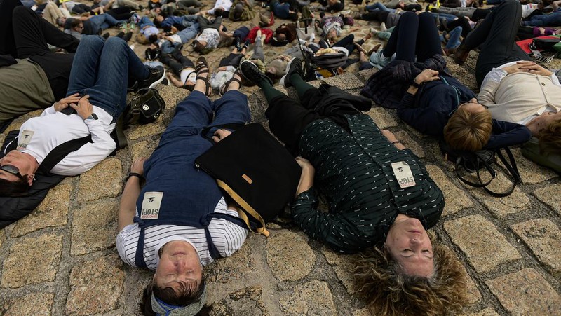 Pro-Palestinian demonstrators lie on the ground as they protest against Israeli attacks on Gaza, in San Sebastian, northern Spain, on Sunday, March 17, 2024. (AP Photo/Alvaro Barrientos)