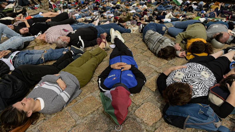 Pro-Palestinian demonstrators lie on the ground as they protest against Israeli attacks on Gaza, in San Sebastian, northern Spain, on Sunday, March 17, 2024. (AP Photo/Alvaro Barrientos)