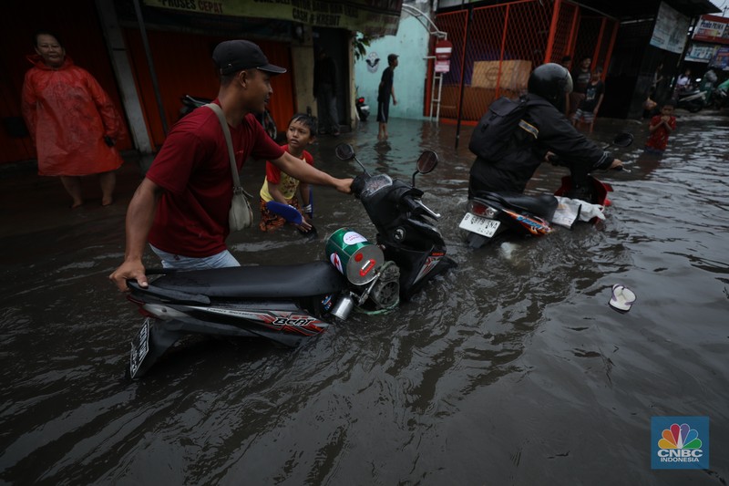 Warga melewati banjir yang merendam di kawasan Puribeta, Ciledug, Tangerang Selatan, Jumat (22/3/2024). (CNBC Indonesia/Tri Susilo)