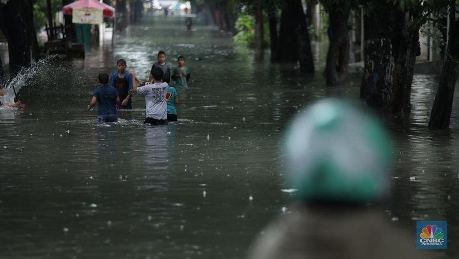 Warga melewati banjir yang merendam di kawasan Puribeta, Ciledug, Tangerang Selatan, Jumat (22/3/2024). (CNBC Indonesia/Tri Susilo)