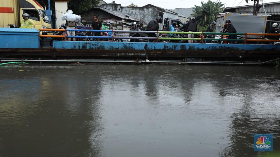 Warga melewati banjir yang merendam di kawasan Puribeta, Ciledug, Tangerang Selatan, Jumat (22/3/2024). (CNBC Indonesia/Tri Susilo)