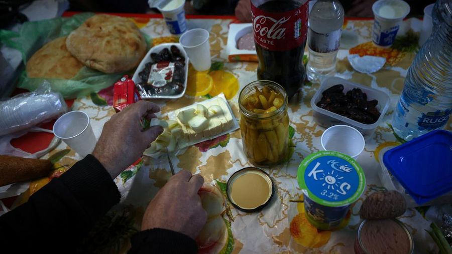 Seorang penambang menyiapkan makanan sebelum berbuka puasa selama bulan Ramadhan, di kantor darurat 800 meter di bawah tanah tempat para penambang makan, di Tambang Trepca, di Stanterg, dekat Mitrovica, Kosovo, 14 Maret 2024. (REUTERS/Florion Goga)