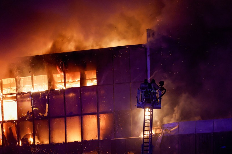 Tim penyelamat bekerja untuk memadamkan api di tempat konser Balai Kota Crocus yang terbakar menyusul insiden penembakan, di luar Moskow, Rusia, 22 Maret 2024. Tim penyelamat bekerja untuk memadamkan api di tempat konser Balai Kota Crocus yang terbakar menyusul insiden penembakan, di luar Moskow, Rusia, 22 Maret 2024. (REUTERS/Maxim Shemetov)