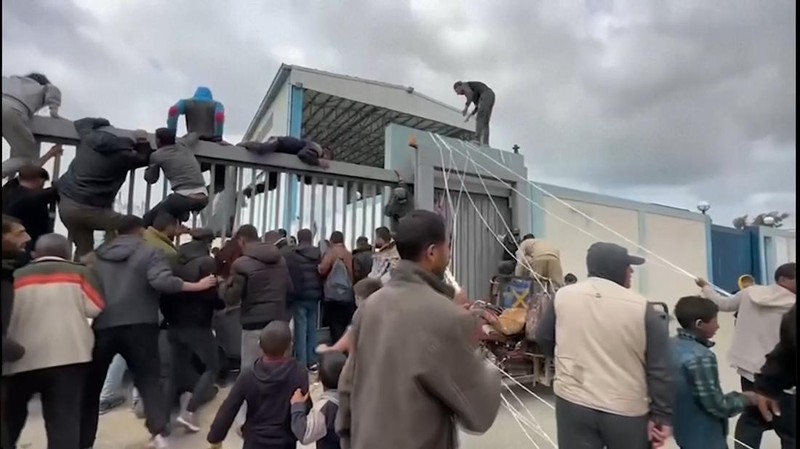 Warga Palestina berbondong-bondong untuk mendapatkan bantuan yang dijatuhkan dari udara pada Jumat (22/3) di Muraj, Gaza selatan. (Tangkapan Layar video AP)