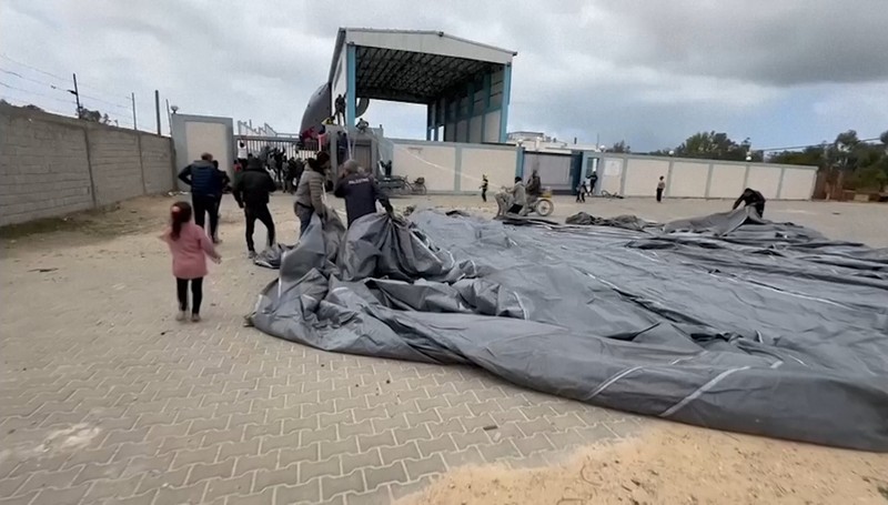 Warga Palestina berbondong-bondong untuk mendapatkan bantuan yang dijatuhkan dari udara pada Jumat (22/3) di Muraj, Gaza selatan. Warga Palestina berbondong-bondong untuk mendapatkan bantuan yang dijatuhkan dari udara pada Jumat (22/3) di Muraj, Gaza selatan. (Tangkapan Layar video AP)