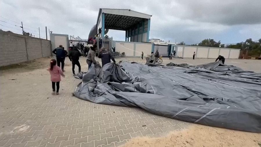 Warga Palestina berbondong-bondong untuk mendapatkan bantuan yang dijatuhkan dari udara pada Jumat (22/3) di Muraj, Gaza selatan. (Tangkapan Layar video AP)