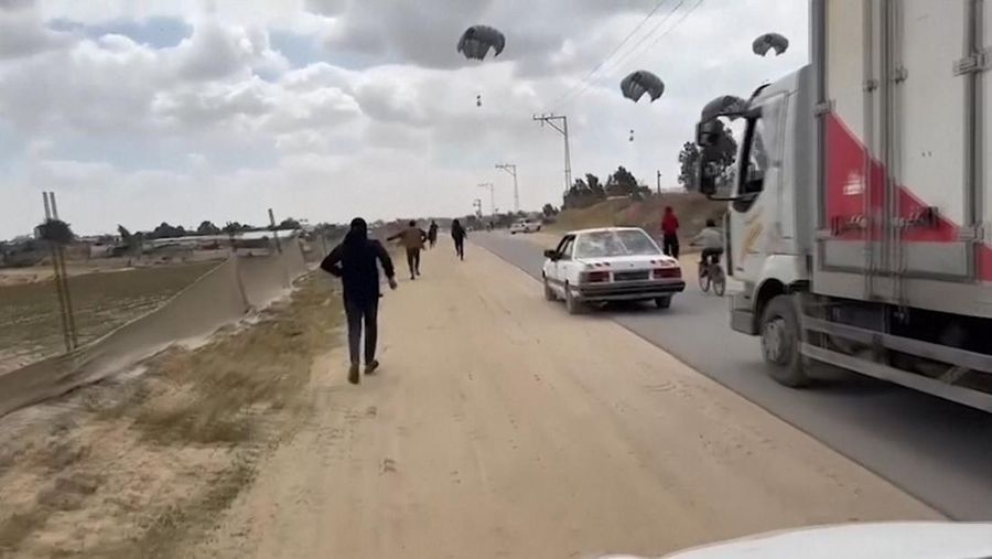 Warga Palestina berbondong-bondong untuk mendapatkan bantuan yang dijatuhkan dari udara pada Jumat (22/3) di Muraj, Gaza selatan. (Tangkapan Layar video AP)