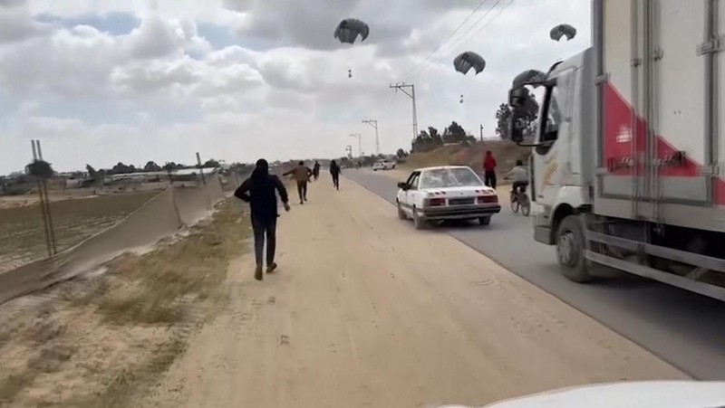 Warga Palestina berbondong-bondong untuk mendapatkan bantuan yang dijatuhkan dari udara pada Jumat (22/3) di Muraj, Gaza selatan. (Tangkapan Layar video AP)
