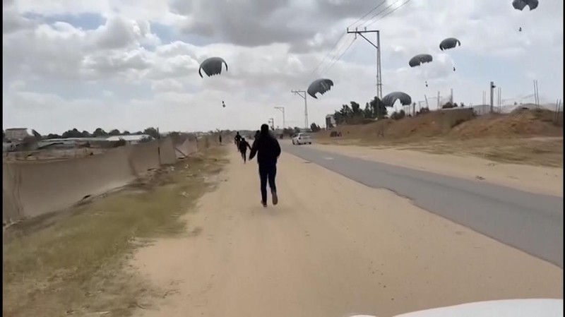 Warga Palestina berbondong-bondong untuk mendapatkan bantuan yang dijatuhkan dari udara pada Jumat (22/3) di Muraj, Gaza selatan. (Tangkapan Layar video AP)