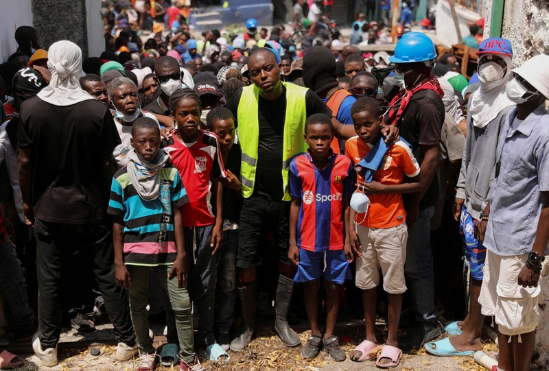 Seorang wanita berlindung dari tembakan di dekat Istana Nasional, di Port-au-Prince, Haiti 21 Maret 2024. (REUTERS/Ralph Tedy Erol)