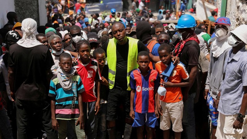 Seorang wanita berlindung dari tembakan di dekat Istana Nasional, di Port-au-Prince, Haiti 21 Maret 2024. (REUTERS/Ralph Tedy Erol)