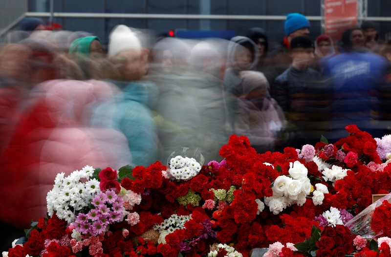 Orang-orang berbaris untuk meletakkan bunga di peringatan darurat bagi para korban serangan penembakan yang diadakan di luar tempat konser Balai Kota Crocus di Wilayah Moskow, Rusia, 24 Maret 2024. (REUTERS/Maxim Shemetov)