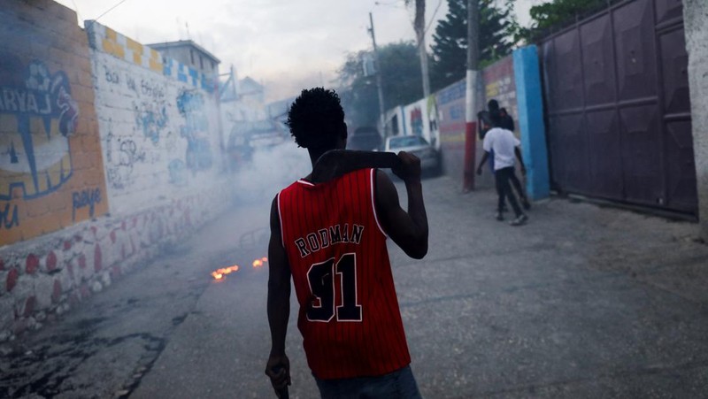 Seorang wanita berlindung dari tembakan di dekat Istana Nasional, di Port-au-Prince, Haiti 21 Maret 2024. (REUTERS/Ralph Tedy Erol)