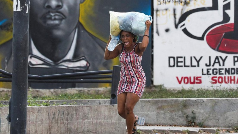 Seorang wanita berlindung dari tembakan di dekat Istana Nasional, di Port-au-Prince, Haiti 21 Maret 2024. (REUTERS/Ralph Tedy Erol)