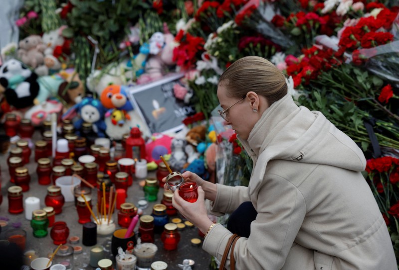 Orang-orang berbaris untuk meletakkan bunga di peringatan darurat bagi para korban serangan penembakan yang diadakan di luar tempat konser Balai Kota Crocus di Wilayah Moskow, Rusia, 24 Maret 2024. (REUTERS/Maxim Shemetov)