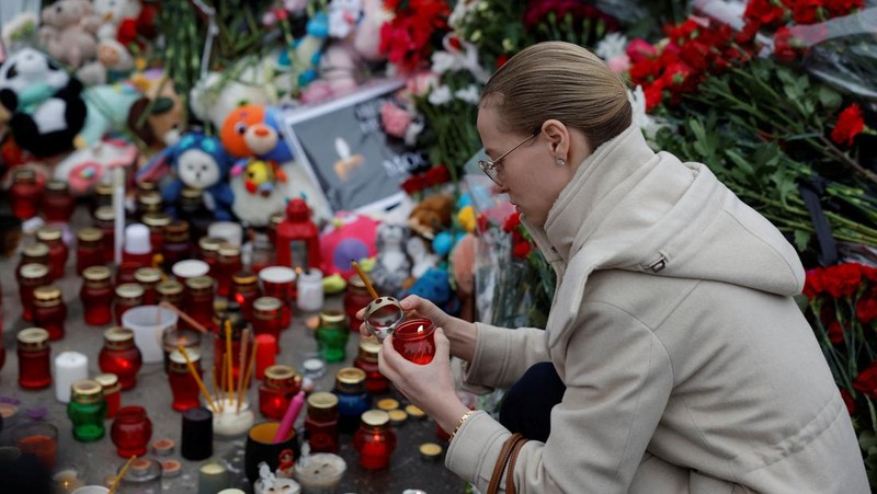 Orang-orang berbaris untuk meletakkan bunga di peringatan darurat bagi para korban serangan penembakan yang diadakan di luar tempat konser Balai Kota Crocus di Wilayah Moskow, Rusia, 24 Maret 2024. (REUTERS/Maxim Shemetov)