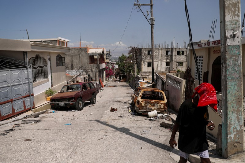 Seorang wanita berlindung dari tembakan di dekat Istana Nasional, di Port-au-Prince, Haiti 21 Maret 2024. (REUTERS/Ralph Tedy Erol)
