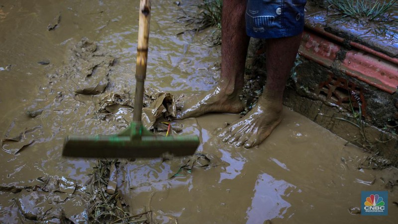 Warga membersihkan rumah usai banjir melanda Kampung Lebak, Kelurahan Teluk Pucung, Kecamatan Bekasi Utara pada Minggu (24/3/2024). (CNBC Indonesia/Tias Budiarto)