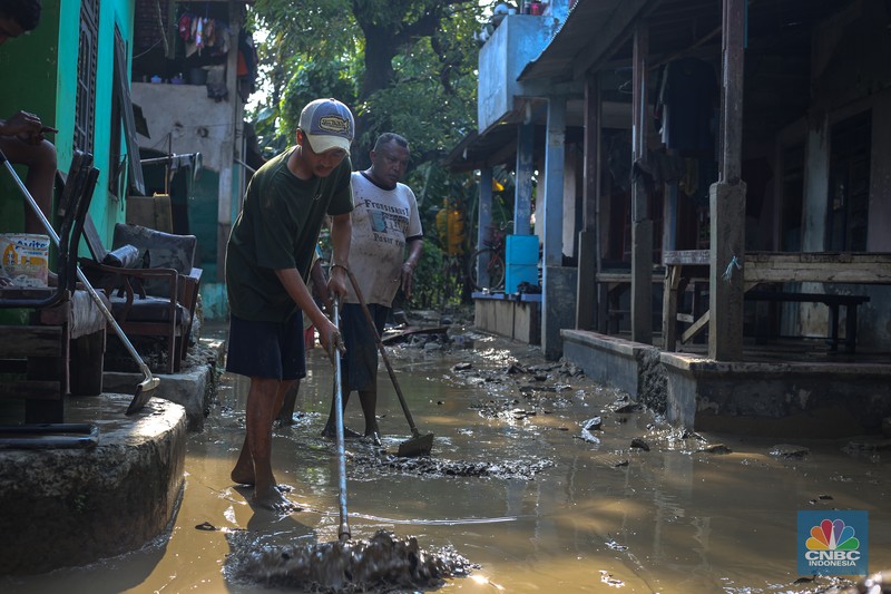 Warga membersihkan rumah usai banjir melanda Kampung Lebak, Kelurahan Teluk Pucung, Kecamatan Bekasi Utara pada Minggu (24/3/2024). (CNBC Indonesia/Tias Budiarto)