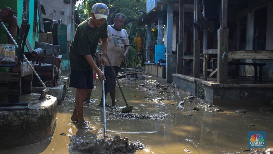 Warga membersihkan rumah usai banjir melanda Kampung Lebak, Kelurahan Teluk Pucung, Kecamatan Bekasi Utara pada Minggu (24/3/2024). (CNBC Indonesia/Tias Budiarto)