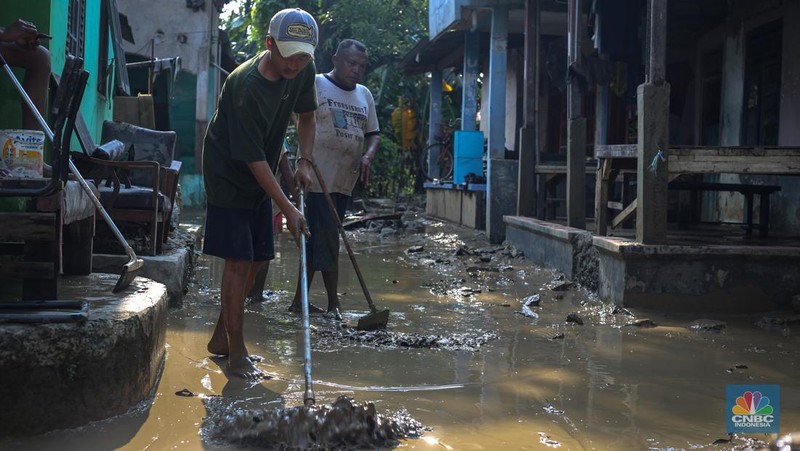 Warga membersihkan rumah usai banjir melanda Kampung Lebak, Kelurahan Teluk Pucung, Kecamatan Bekasi Utara pada Minggu (24/3/2024). (CNBC Indonesia/Tias Budiarto)