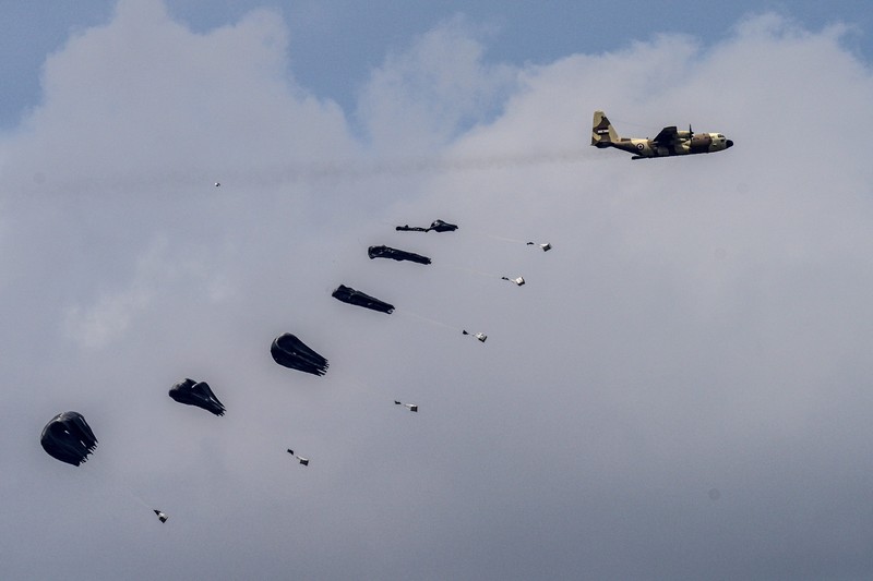 APTOPIX Israel Palestinians An aircraft airdrops humanitarian aid over the northern Gaza Strip, as seen from southern Israel, Sunday, March 24, 2024. (AP Photo/Tsafrir Abayov)