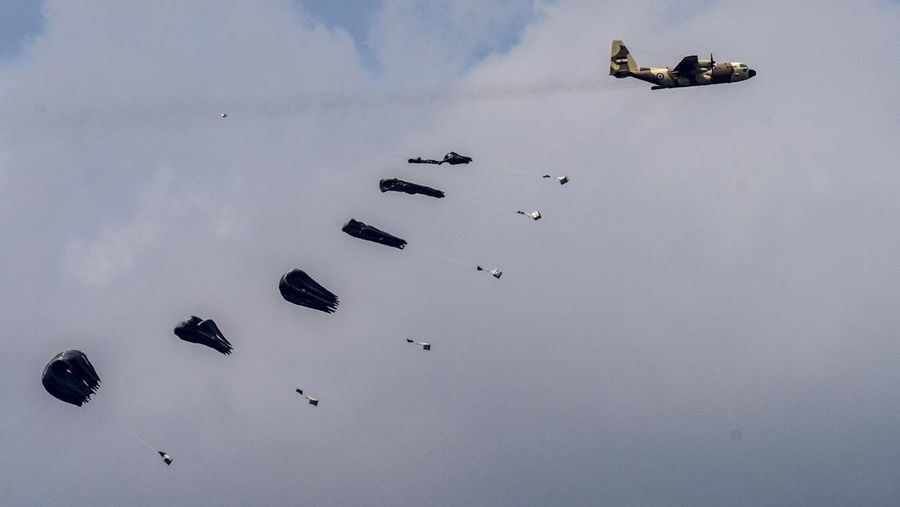 An aircraft airdrops humanitarian aid over the northern Gaza Strip, as seen from southern Israel, Sunday, March 24, 2024. (AP Photo/Tsafrir Abayov)