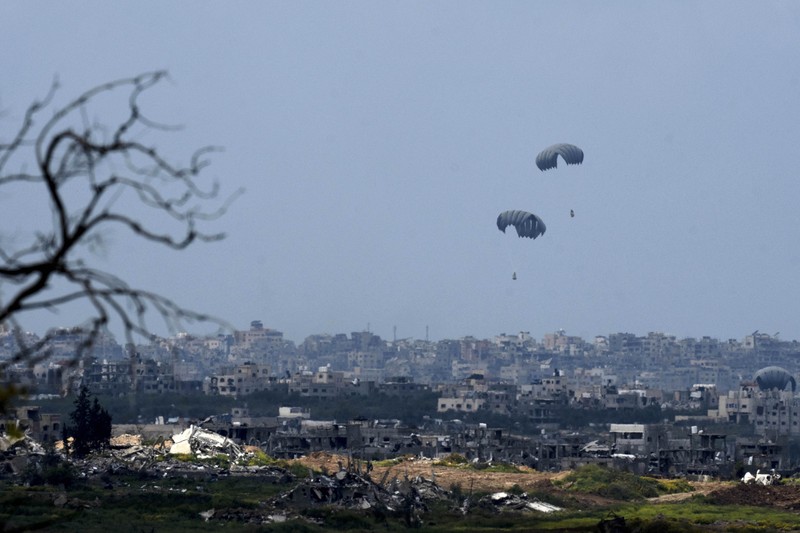 APTOPIX Israel Palestinians An aircraft airdrops humanitarian aid over the northern Gaza Strip, as seen from southern Israel, Sunday, March 24, 2024. (AP Photo/Tsafrir Abayov)