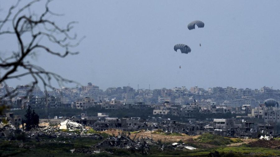 An aircraft airdrops humanitarian aid over the northern Gaza Strip, as seen from southern Israel, Sunday, March 24, 2024. (AP Photo/Tsafrir Abayov)